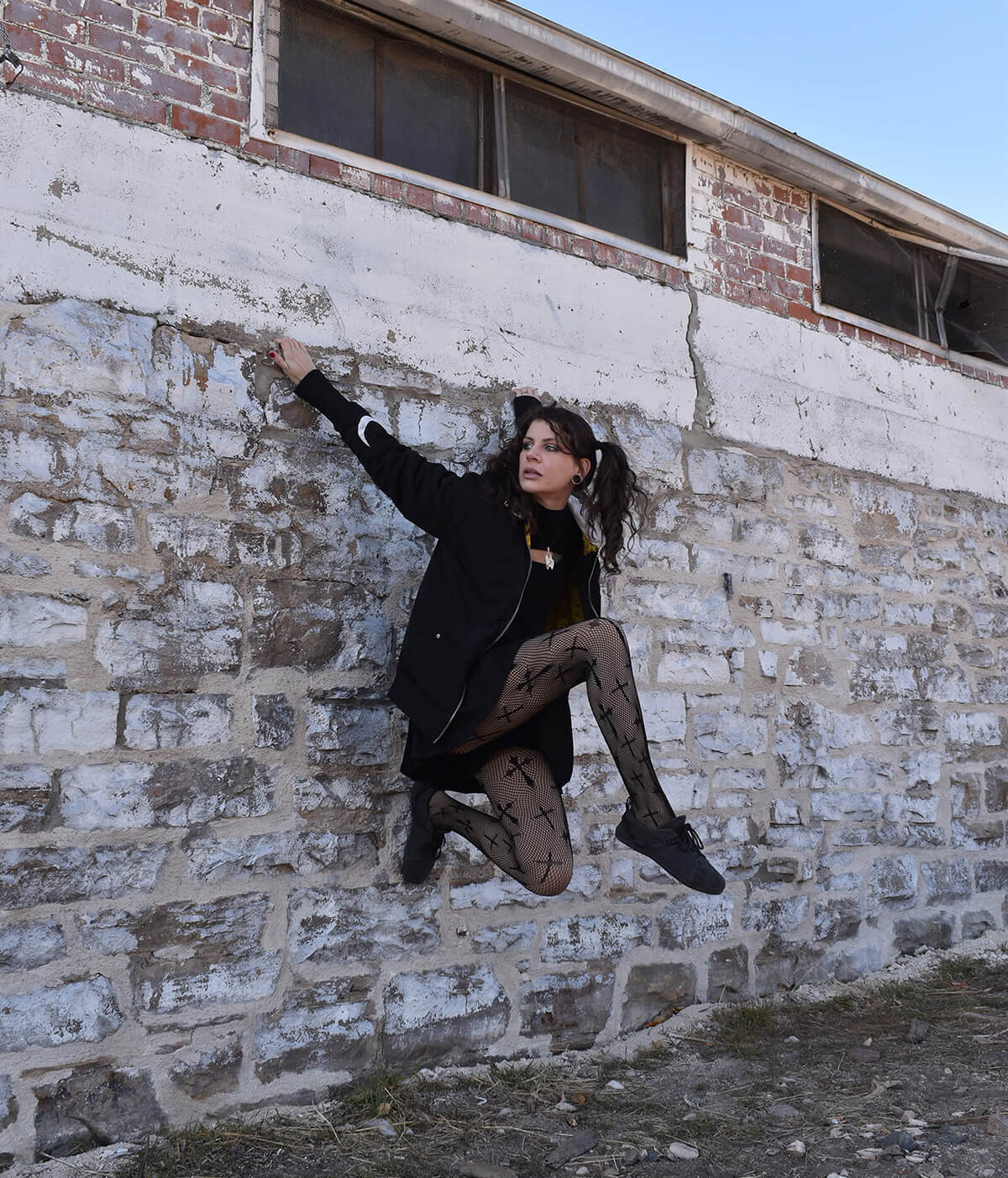 girl handing from ledge on a wall